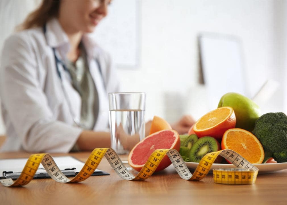 Nutritionist professional with plate of food and measuring tape