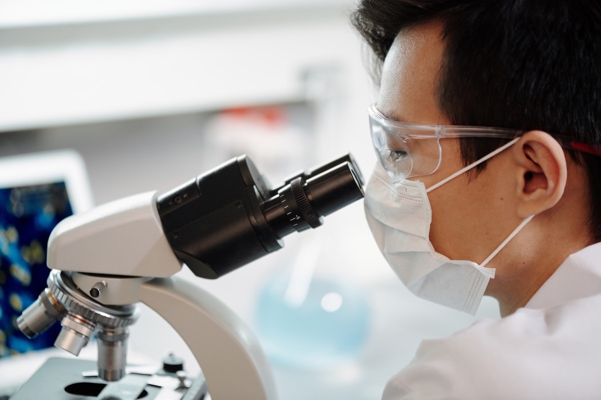 person looking into microscope