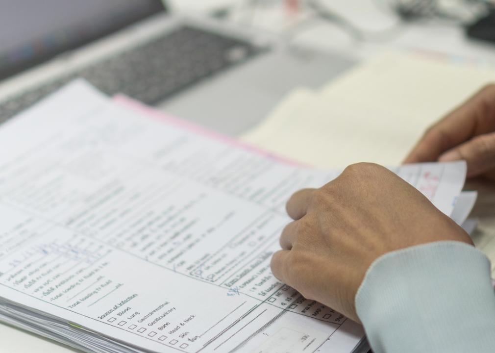 Hands flipping through printed medical records.