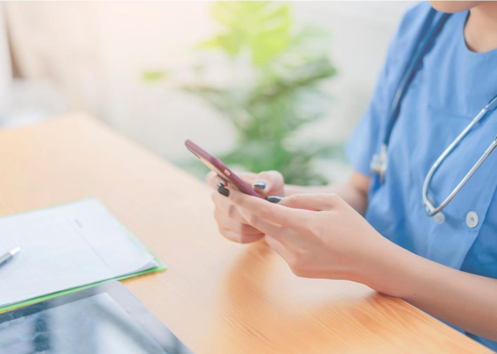 A medical professional scrolling through phone. 