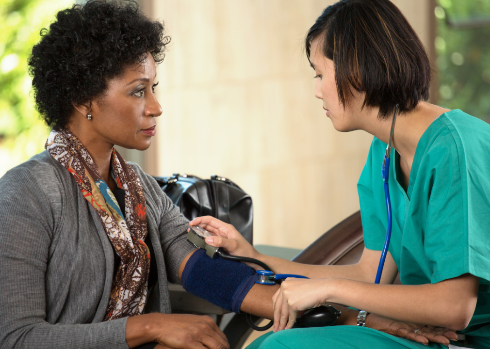 Nurse checking woman's blood pressure.